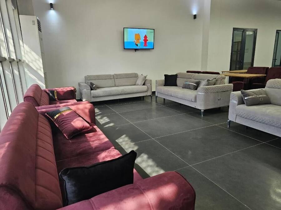 Un salon moderne comprenant un canapé, un téléviseur à écran plat et une table.
