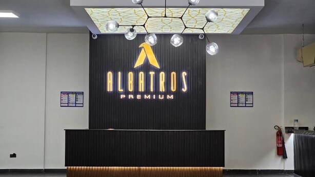 A reception desk with a logo and name "Alaotraos Premium" on the wall. - Albatros Premium Hôtel (Yaoundé)