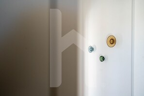 A door with a large, abstract design on the wall, a round doorknob, and a rectangular handle.