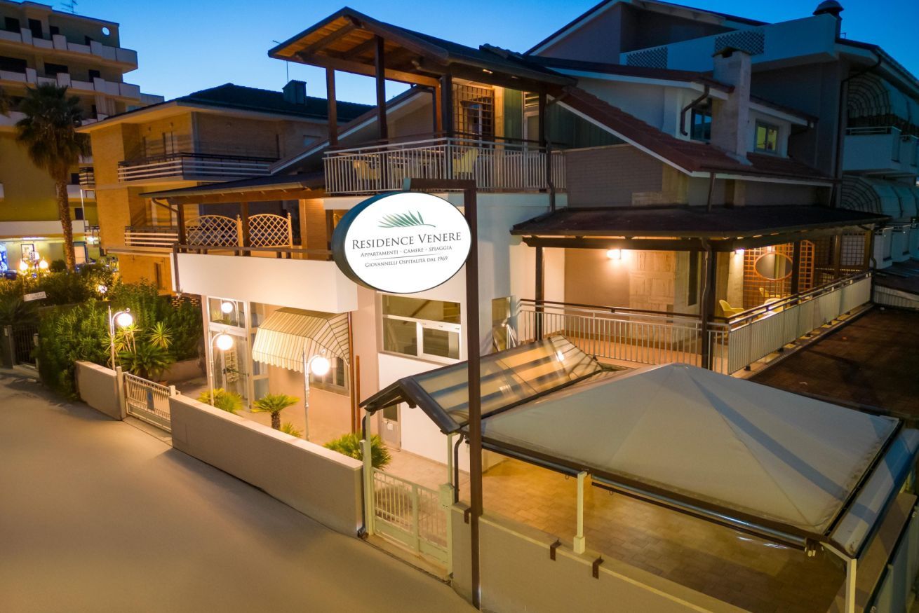 A multi-story hotel with a prominent sign, balconies, and a covered outdoor area.