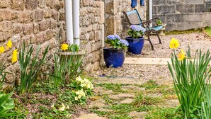 A stone wall with a bench and potted plants.