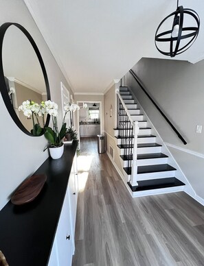 Eine moderne Treppe mit Schwarz-Weiß-Design, die zu einem Küchenbereich führt.