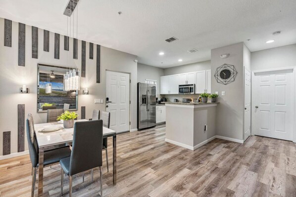 A modern kitchen with white cabinets, stainless steel appliances, and a central island. - Thematic 4 bdr Near Disney-22101 (Kissimmee)