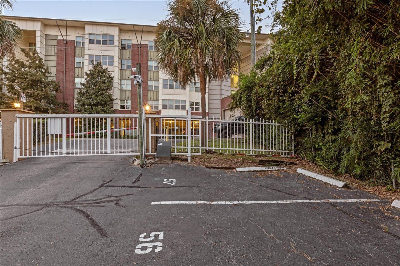 A gated parking area with a building in the background.