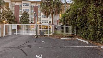 A gated parking area with a building in the background.