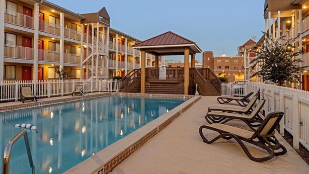 A hotel with a swimming pool, outdoor seating, and a covered gazebo. - The Ward - Resort Style Gameday Condo (Tallahassee)