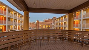 A hotel with multiple balconies, wooden deck, and a view of other buildings in the background. - The Ward - Resort Style Gameday Condo (Tallahassee)