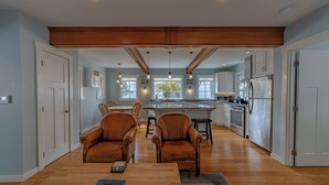 A spacious kitchen with wooden flooring, a central island, and modern appliances.