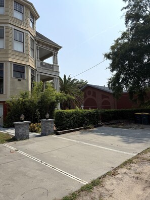 A multi-story building with a balcony, a parking area, and a red brick structure in the background. - Private studio/parking in historic mansion, close to forsyth park, dogs welcome (Savannah)