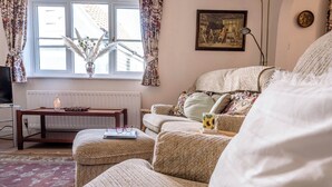 Ein gemütliches Wohnzimmer mit einer Couch, einem Couchtisch und einer Heizung.