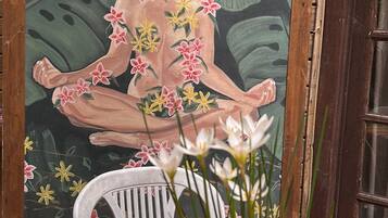 A potted plant on a colorful striped tablecloth with a mural in the background.