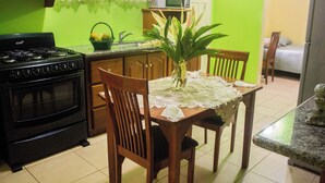A kitchen with a stove, microwave, and dining table with chairs. - A Trini Paradise - 4 bedroom apartment with WiFi, AC in enjoyable Tunapuna (Tunapuna)