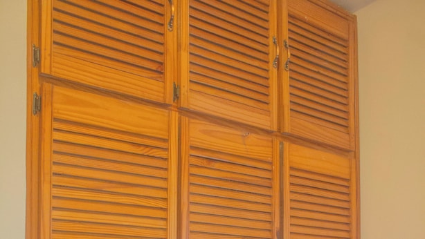 A wooden wardrobe with multiple compartments and a mattress at the bottom. - A Trini Paradise - 4 bedroom apartment with WiFi, AC in enjoyable Tunapuna (Tunapuna)