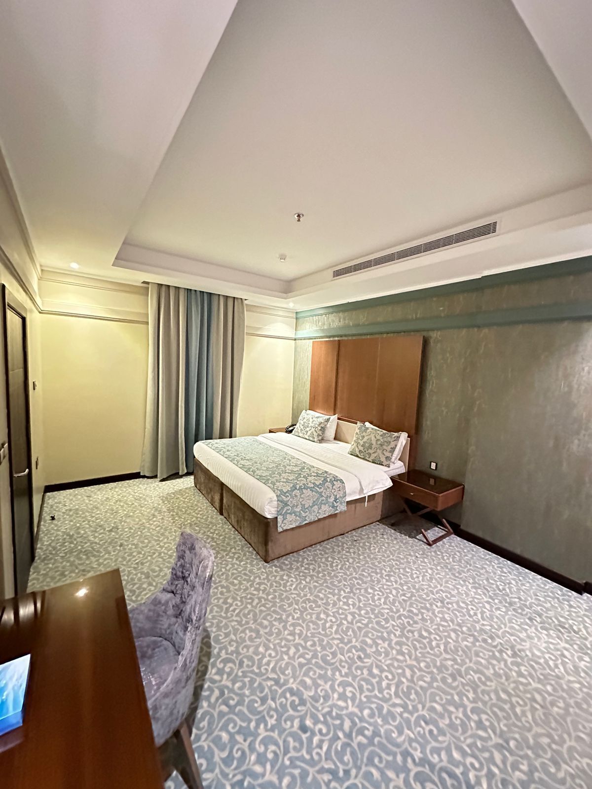 Una habitación de hotel con una cama, un escritorio y una silla.