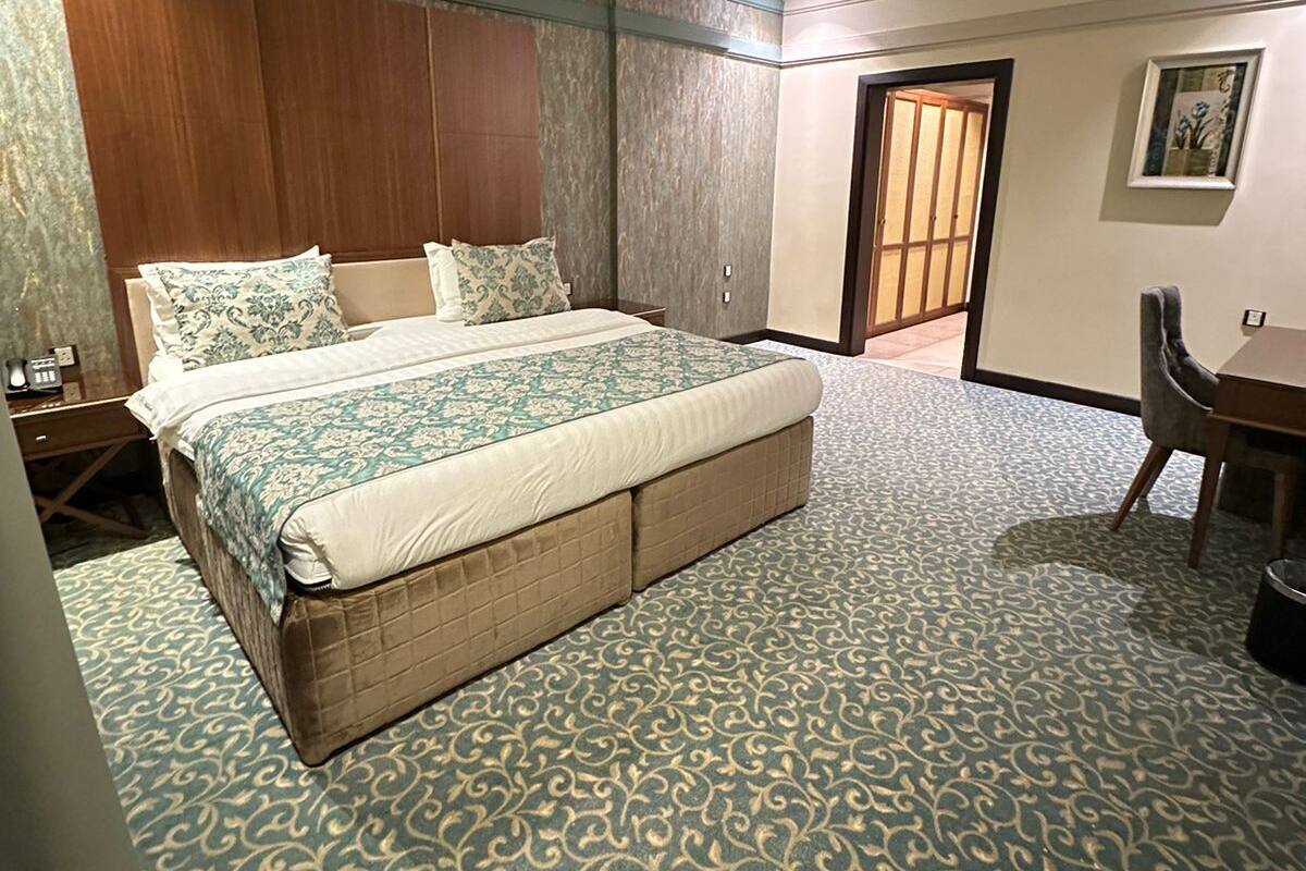Ein Hotelzimmer mit einem großen Bett, einem Schreibtisch und einem Stuhl.