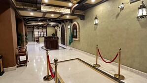 A spacious lobby with a high ceiling, chandeliers, and a reception desk. - Wow Al Zahra Apartments (Jeddah)