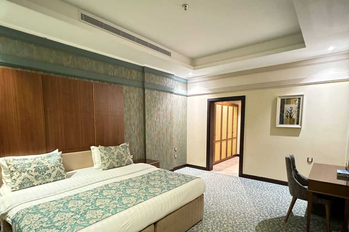 Ein Hotelzimmer mit einem großen Bett, einem Schreibtisch und einem Stuhl.