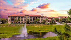 A hotel with a large building, a fountain, and a pond. - Entire Condo 3B3B/Resort Style/Close to theme park (Davenport)