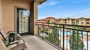 A balcony with a view of a swimming pool and hotel buildings. - Entire Condo 3B3B/Resort Style/Close to theme park (Davenport)