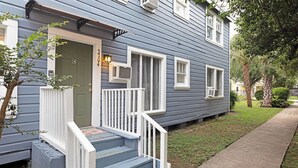A two-story house with a front porch, a green door, and a mailbox.