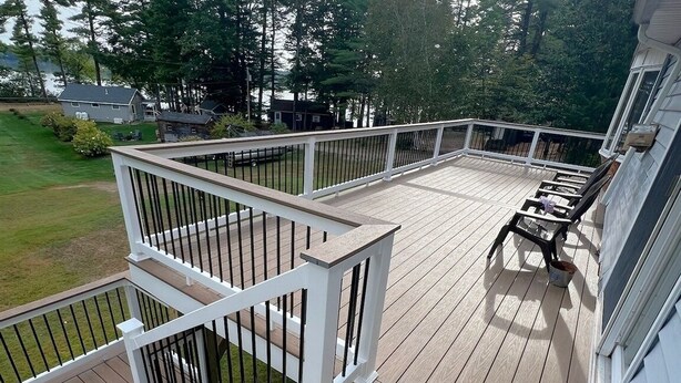 A wooden deck with white railings, a small table, and a chair. - Loons View Limit 20 5 Bedroom Home (Naples)