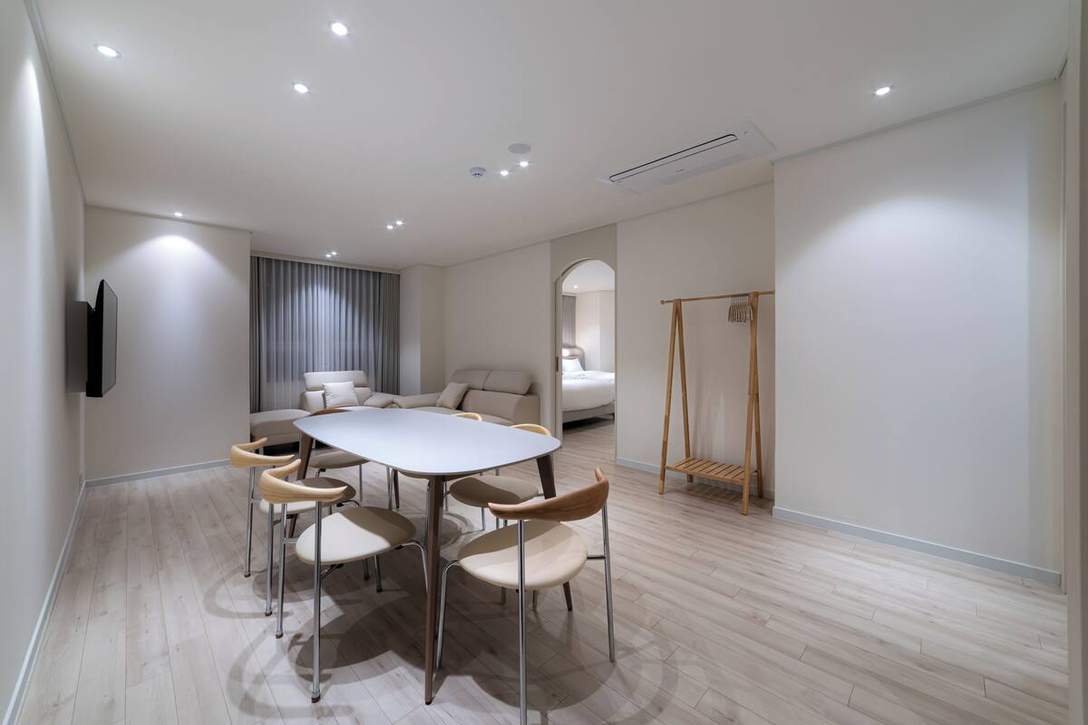 Una habitación moderna con una mesa de comedor, sillas, un sofá, un televisor y un columpio.