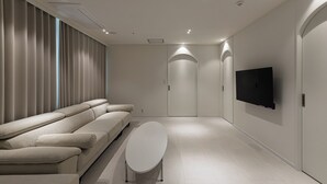 A modern living room with a sofa, a coffee table, and a flat-screen TV.
