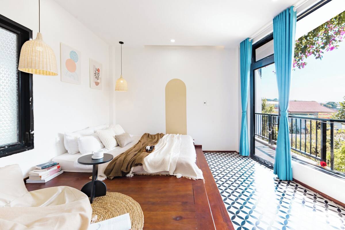 A modern living room with a sofa, a coffee table, and a view of the outside balcony.