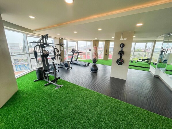 A gym with treadmills, weight machines, and a punching bag.