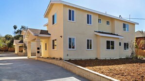A two-story house with a beige exterior, a covered porch, and a landscaped front yard. - 1280A - 2-bedroom/2 bathrooms in Pasadena (Pasadena)