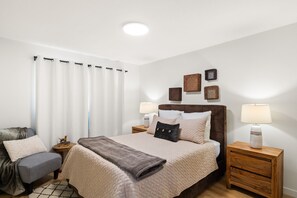 Cozy retreat with a large bed, bedside tables, and a comfortable armchair.