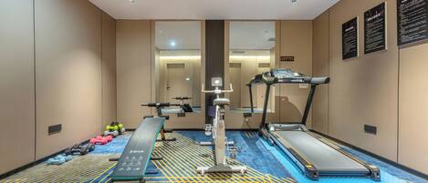 A gym with treadmills, a stationary bike, and free weights.