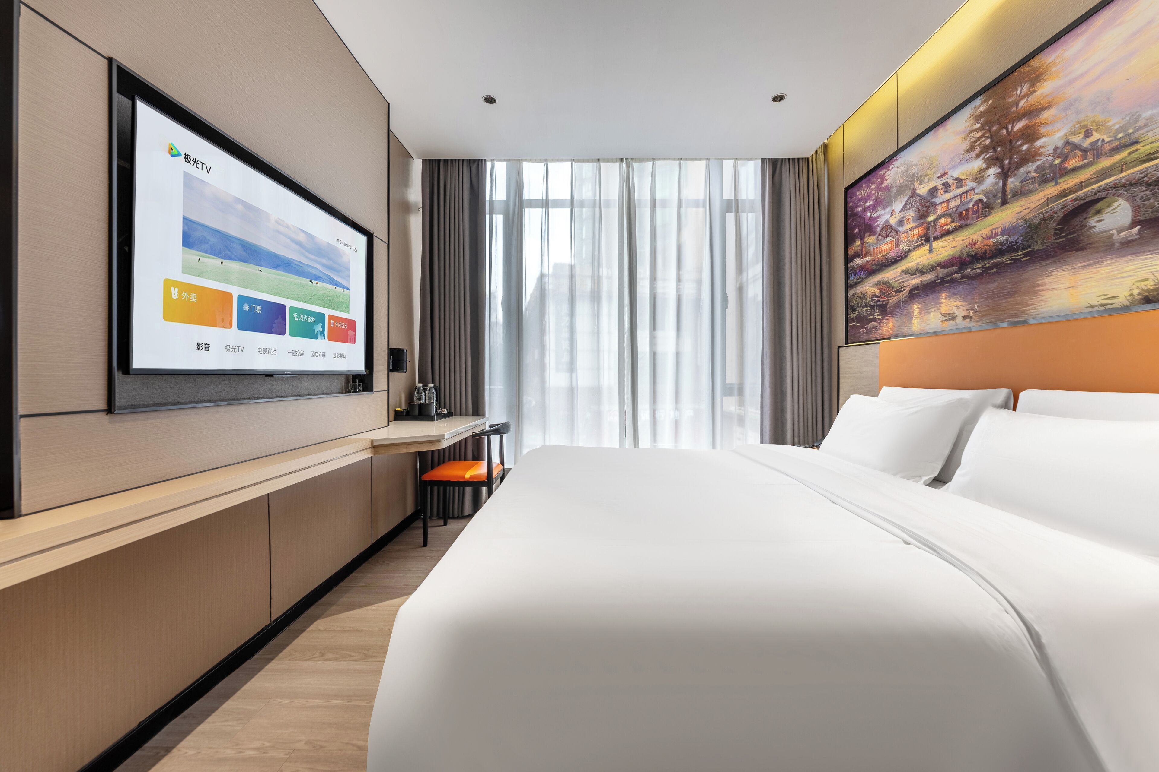 Ein modernes Hotelzimmer mit einem großen Bett, einem flachbildfernseher an der Wand, einem Schreibtisch mit Stuhl und einem Gemälde über dem Bett.