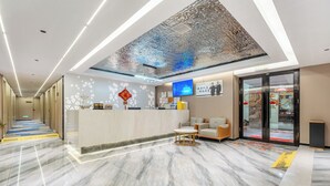 A hotel reception area with a marble floor, a reception desk, a seating area, and a large screen displaying information. - Norman Hotel - Binjiang East Road Subway Station, Haizhu District, Guangzhou - Free shuttle service during the Canton Fair (Guangzhou)