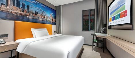A modern hotel room with a large bed, a desk, and a cityscape painting on the wall.