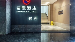 A hotel reception area with a neon sign for NUOMANHOTEL, a marble reception desk, and a staircase in the background. - Norman Hotel - Binjiang East Road Subway Station, Haizhu District, Guangzhou - Free shuttle service during the Canton Fair (Guangzhou)