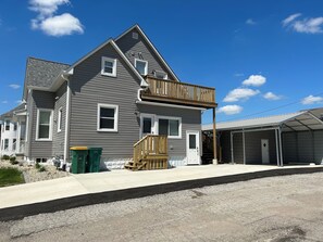 Une maison à deux étages avec un balcon, un garage et une allée.