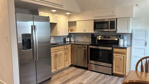 A modern kitchen with stainless steel appliances, wooden cabinets, and a tiled backsplash. - Main Stay on Market Unit 3 -Healthcare and Military Friendly (Mascoutah)
