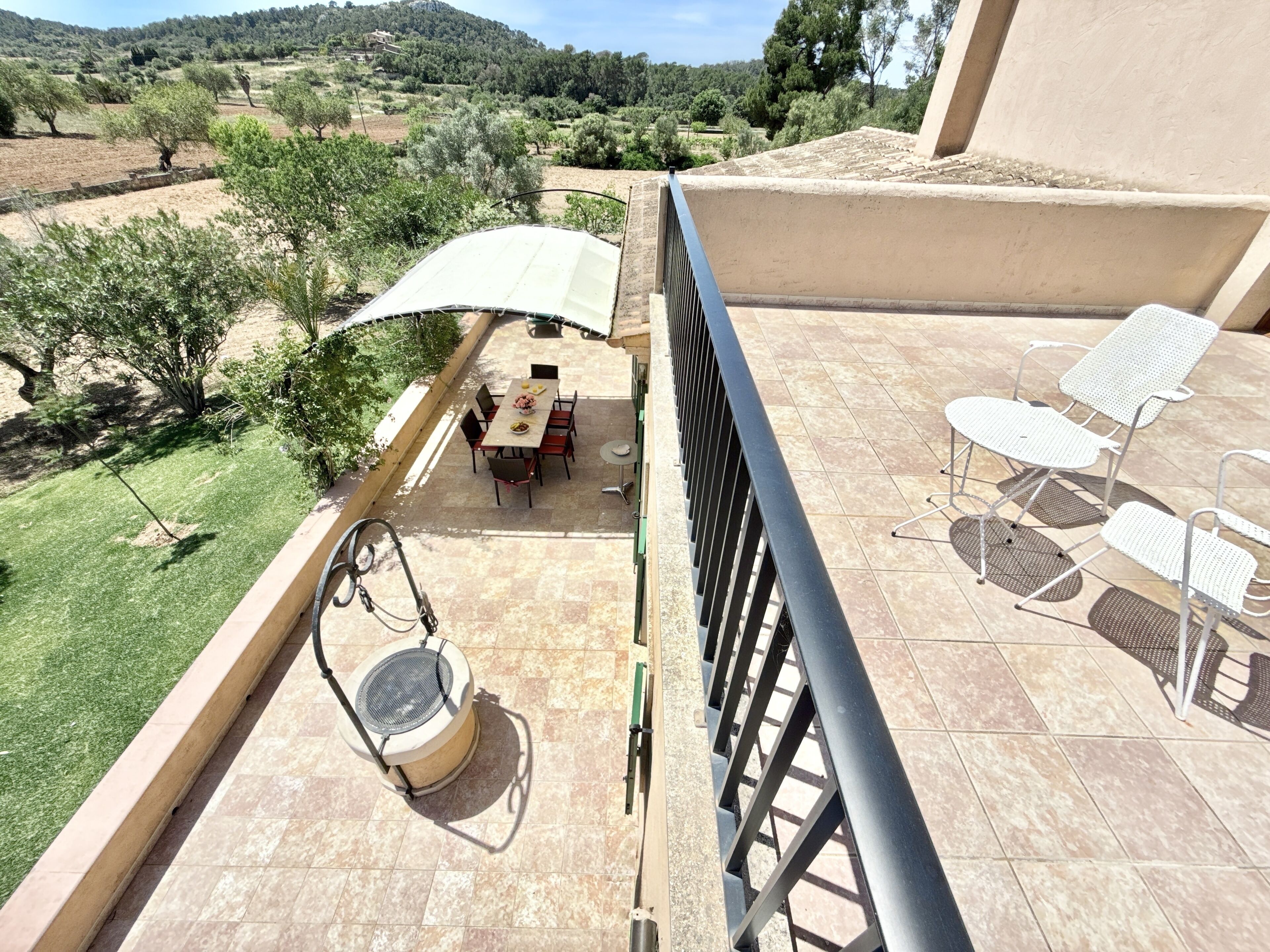 Une terrasse avec une table et des chaises, un tambour et une vue sur le paysage environnant.