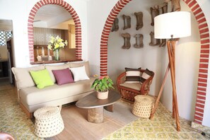 A cozy living room with a sofa, armchairs, a coffee table, and a floor lamp.