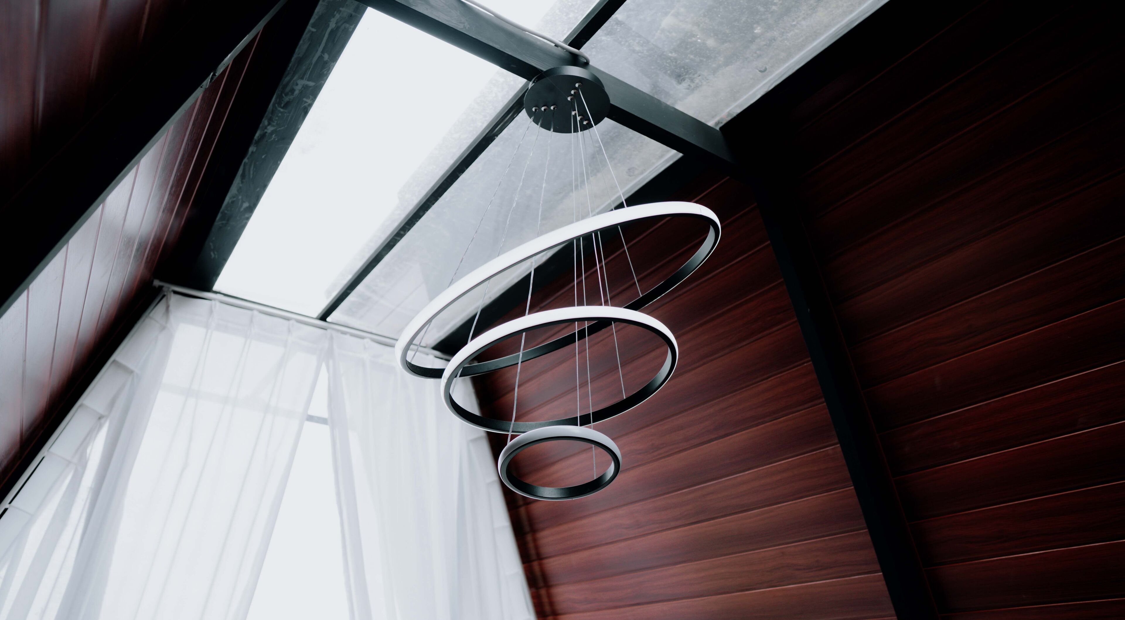 A modern interior with a wooden ceiling and a circular light fixture.