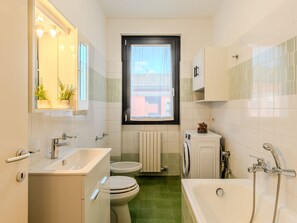 Un baño pequeño con inodoro, bidé, lavabo y bañera.