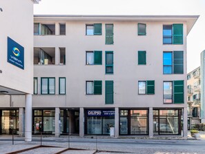 Un edificio de varios pisos con un cartel que indica “VISIVA Studio Oculistico” a la izquierda.