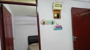 A room with a bed, a wall-mounted electrical box, and a sign that says "sweet home." - Homestay Budget Alor Setar (Jitra)