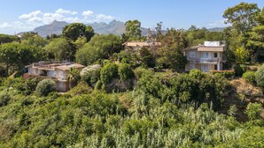 A hillside residential area with houses, lush greenery, and mountains in the background. - Cicladi Amorgos by Interhome (Santa Flavia)