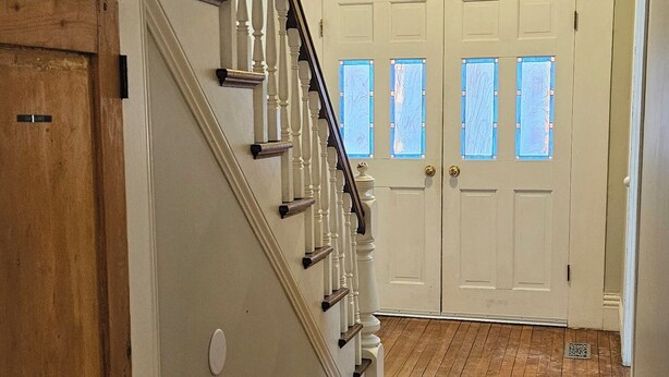A wooden staircase with white balusters leading to a landing with a light fixture. - Scenic Shelburne home. Central location close to Shelburne Harbour. (Shelburne)