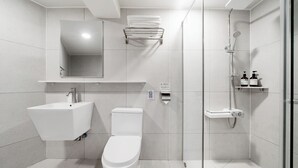 A modern bathroom with a sink, toilet, and shower.