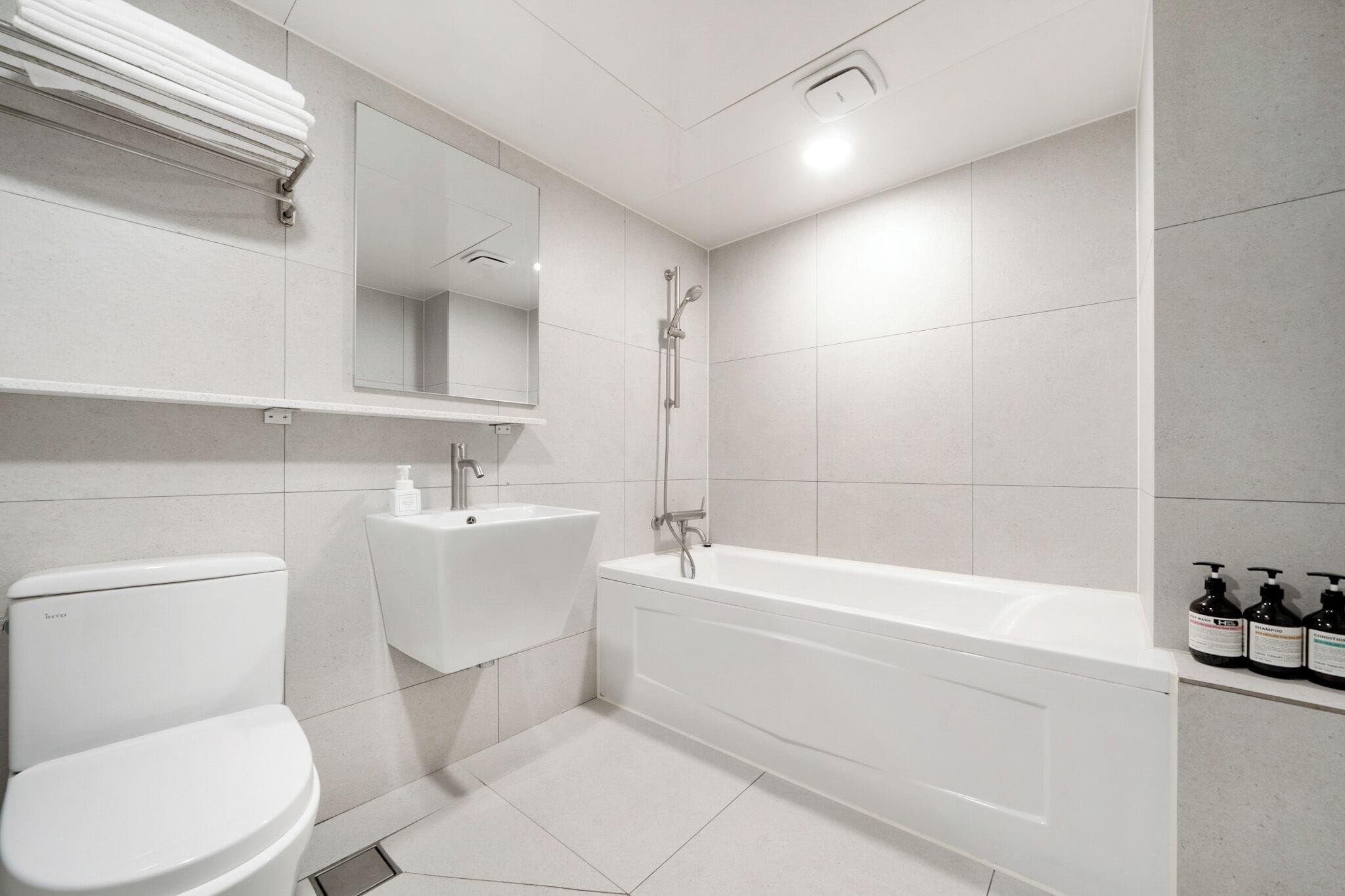 Une salle de bain moderne équipée de toilettes, d’un lavabo et d’une baignoire.