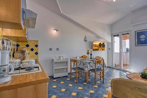 A modern kitchen with a gas stove, a sink, and a countertop with various kitchen utensils.