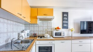 Une cuisine moderne équipée d’une cuisinière à gaz, d’un four, d’un four à micro-ondes et d’une machine à café.